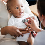 Baby being examined with a stethoscope