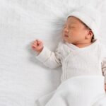Baby sleeping peacefully on a soft white blanket