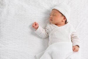 Baby sleeping peacefully on a soft white blanket
