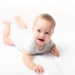 Smiling baby propped up on their arms during tummy time